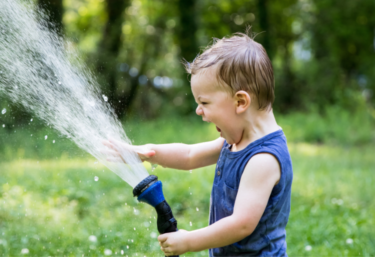 Boy using a hose featuring a trigger nozzle